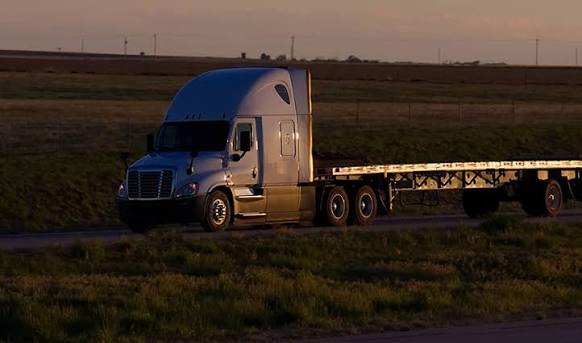 Freight truck travelling through a wooded route